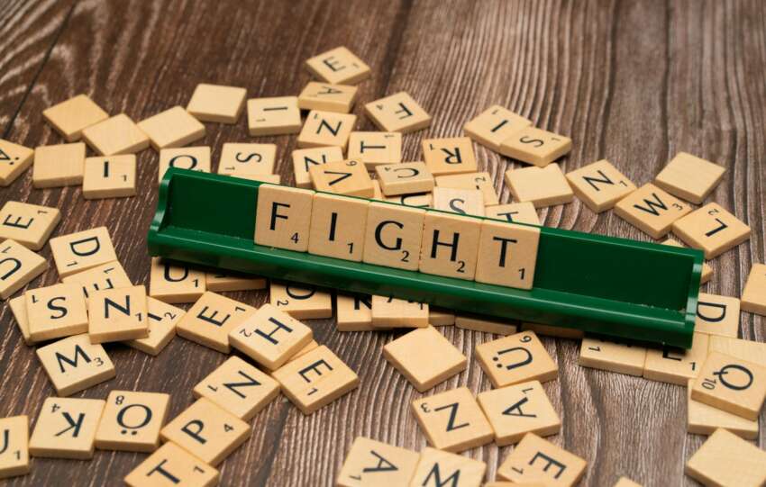 The word fight is spelled out in scrabble tiles