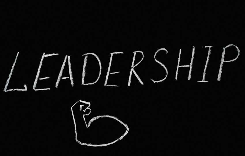 Chalkboard art showcasing the word 'Leadership' and a drawn muscle symbolizing strength.