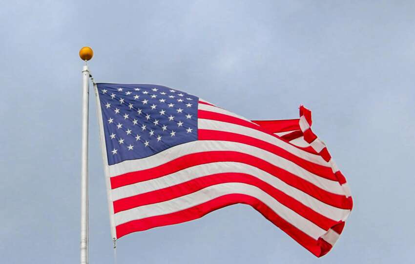 A vibrant image of the American flag waving proudly against a clear blue sky, symbolizing freedom.