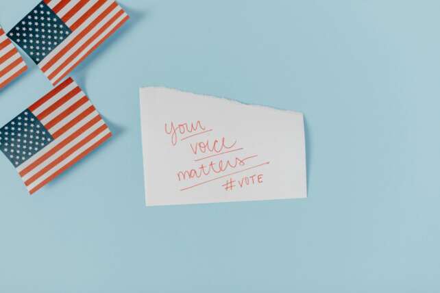 American flags with a motivational note on a blue background urging people to vote. #vote