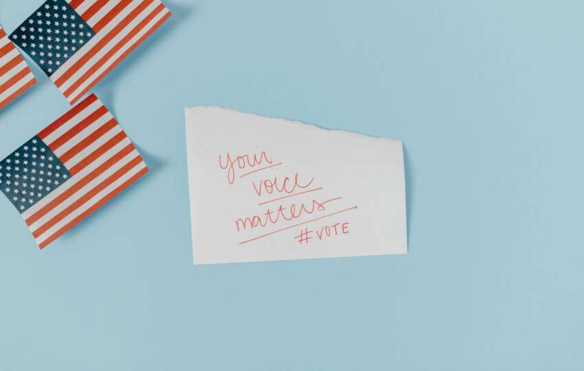 American flags with a motivational note on a blue background urging people to vote. #vote