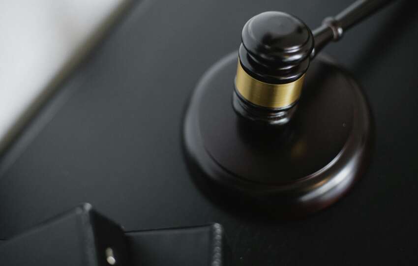 Close-up of a wooden judge's gavel on a black desk, symbolizing justice and law.