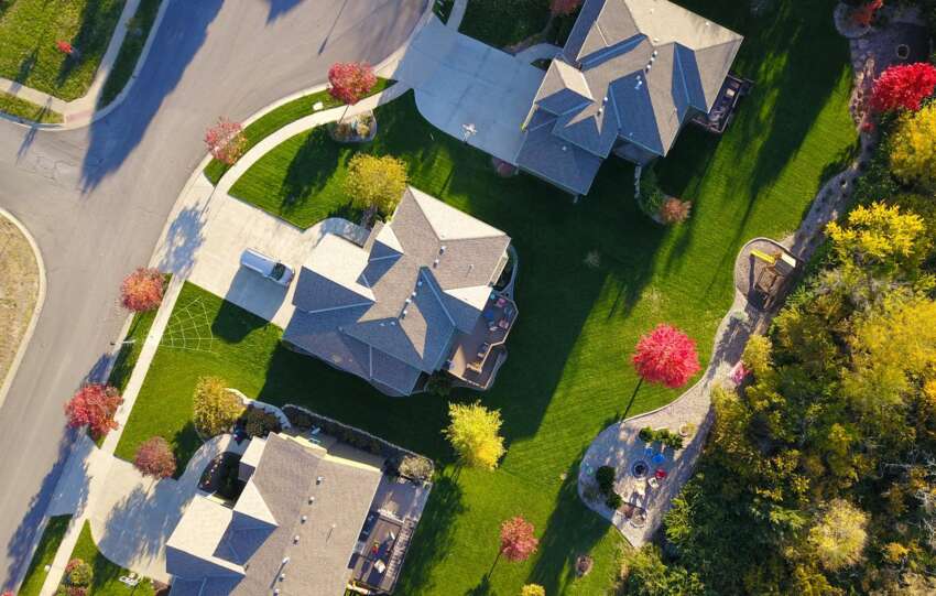 A picturesque aerial view showcasing suburban homes with vibrant gardens and tree-lined streets.