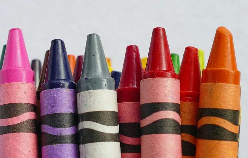 A vibrant collection of colorful crayons arranged in a row, perfect for arts and crafts.