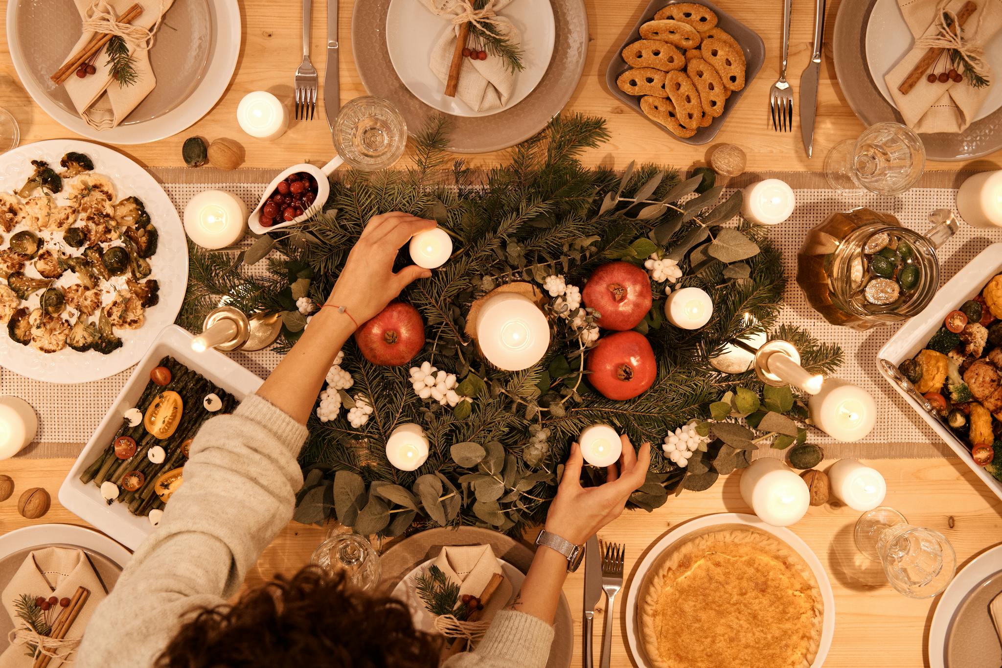 A top-down view of a festive holiday table setting with candles and decorations, perfect for Christmas or New Year's dinner.
