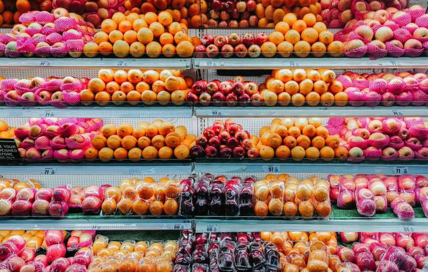 Colorful variety of fresh fruits neatly arranged on supermarket shelves, showcasing abundance and freshness.