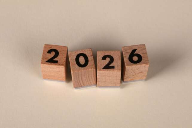 Wooden cubes forming the year 2026 on a neutral background.
