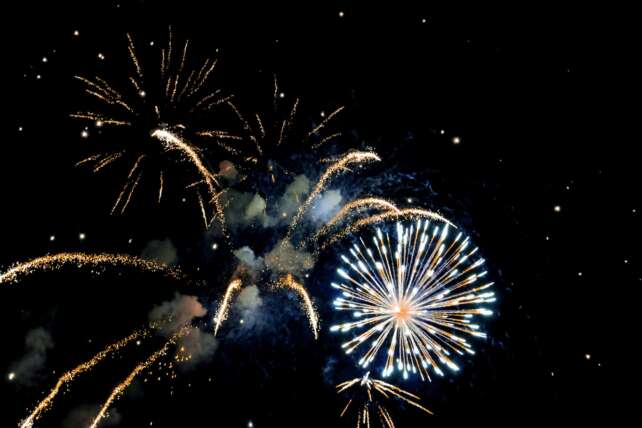 Vibrant fireworks illuminate the night sky, celebrating a festive event with bright and vivid explosions.