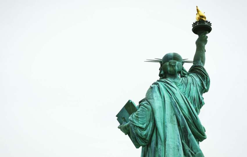 The Statue of Liberty stands tall against a clear sky, symbolizing freedom in New York City.