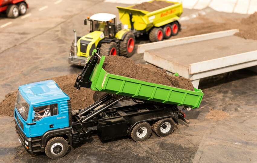 High-angle view of toy trucks on a model construction site showcasing a realistic mini landscape.