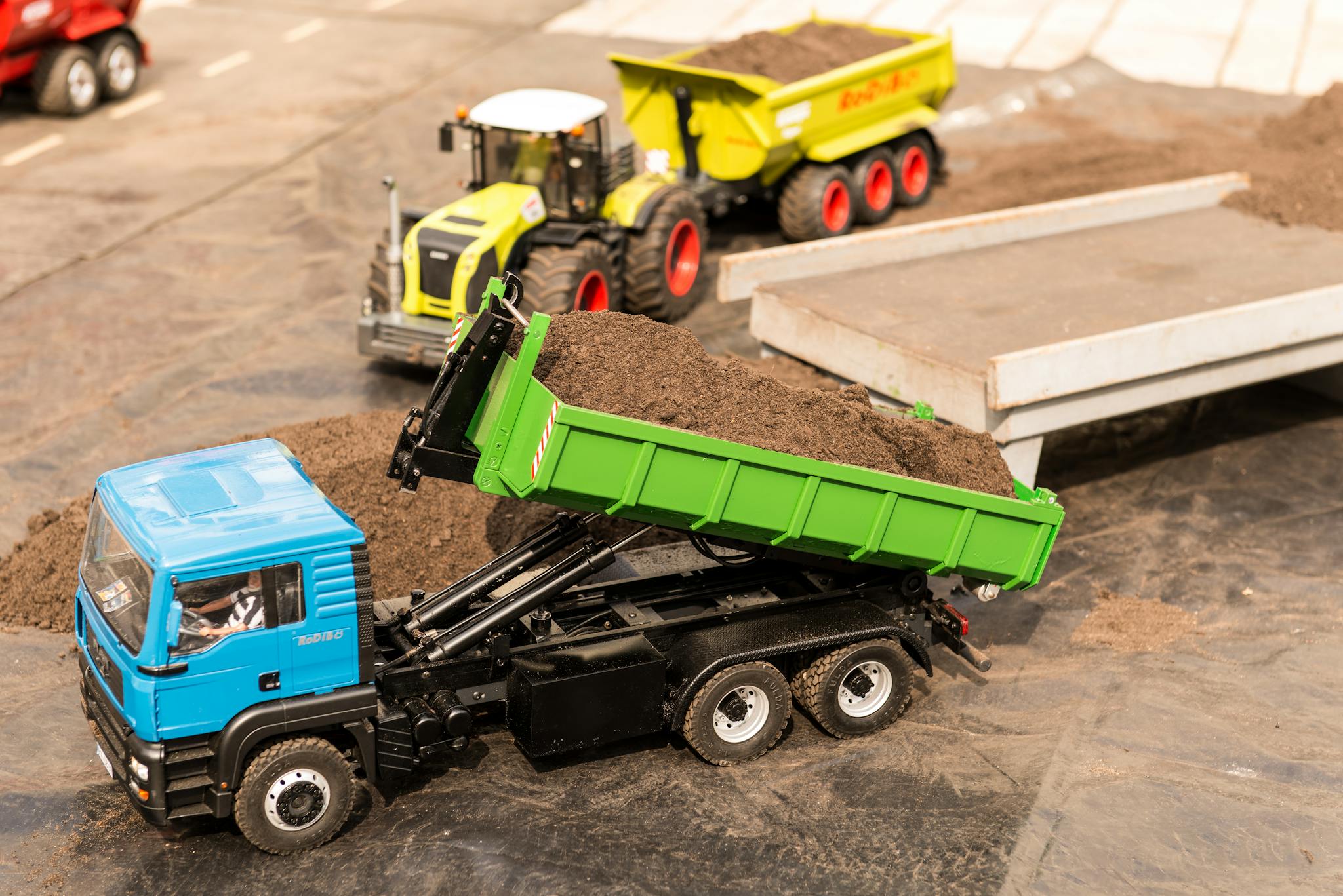 High-angle view of toy trucks on a model construction site showcasing a realistic mini landscape.